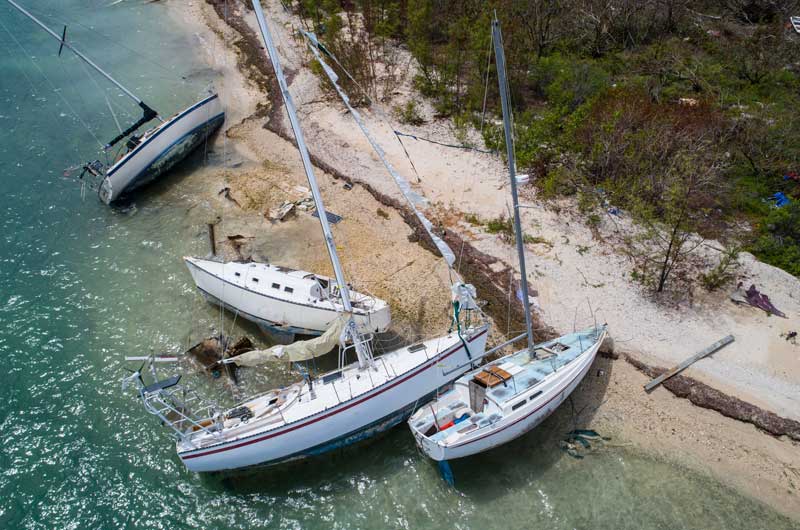 Four sailboats aground on beach after hurricane. Sea Tow offers more than just boat towing services.