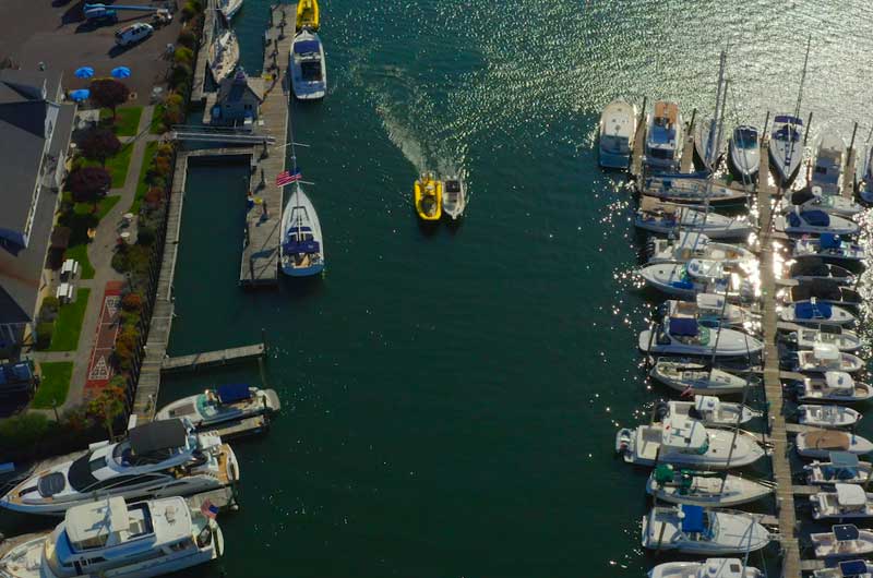 drone photo of boat being towed into a marina