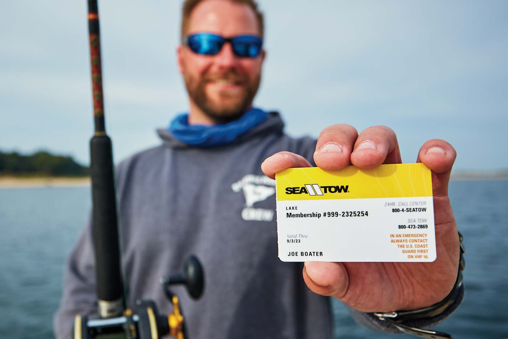Man holding a Sea Tow Lake Card Membership card.